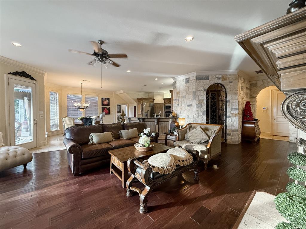 1919 Kings Pass Heath, TX 75032 - Photo 21 of 38 Living area featuring ornamental molding, arched walkways, wood-type flooring, hanging lights, and a ceiling fan
