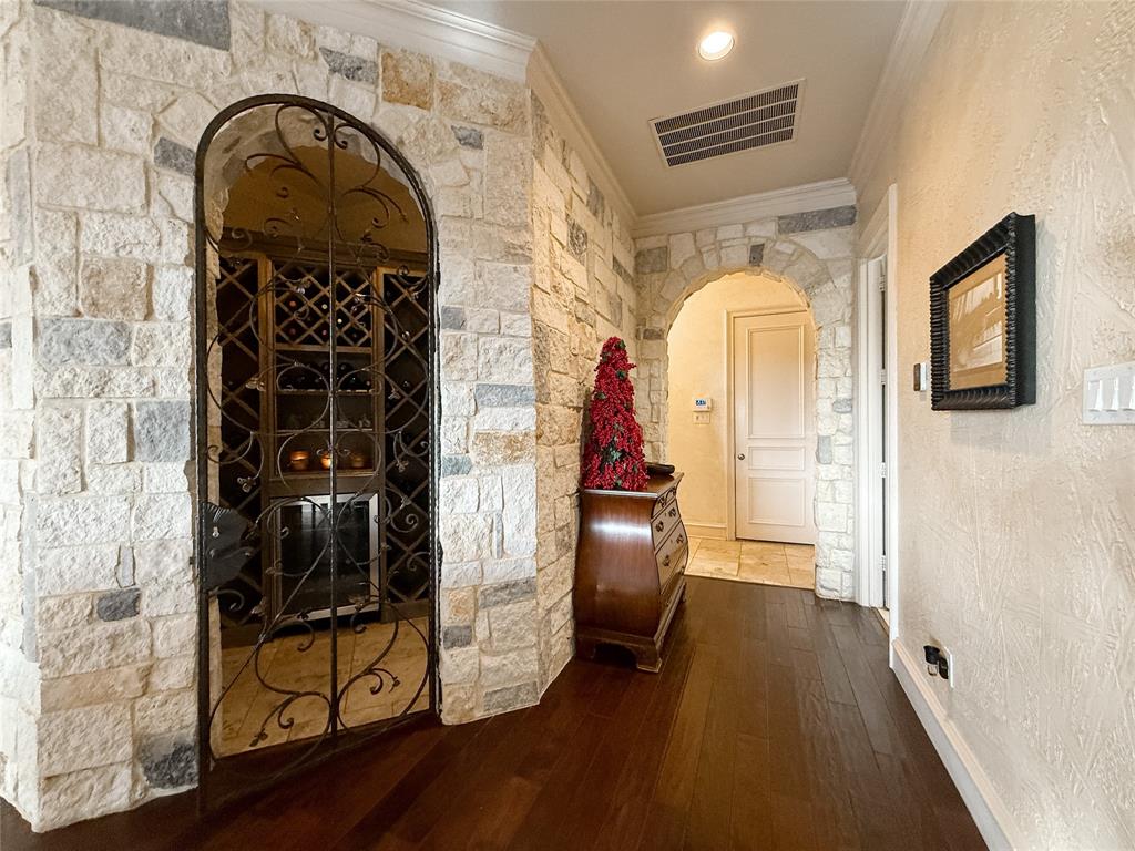 1919 Kings Pass Heath, TX 75032 - Photo 22 of 38 Hall featuring arched walkways, dark wood-type flooring, a textured wall, and ornamental molding