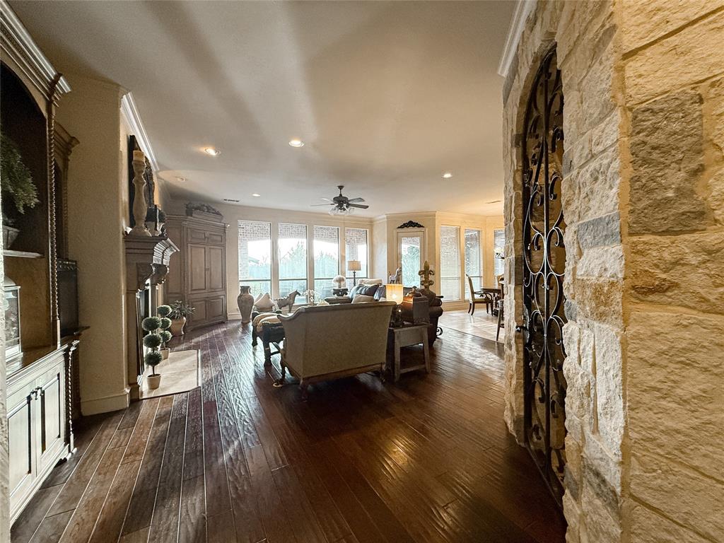 1919 Kings Pass Heath, TX 75032 - Photo 24 of 38 Living room with dark wood-style floors, a fireplace, recessed lighting, a ceiling fan, and crown molding