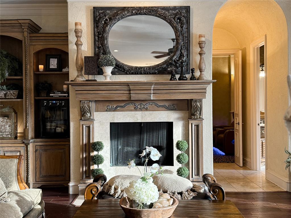 1919 Kings Pass Heath, TX 75032 - Photo 25 of 38 Living room with arched walkways, a fireplace, wood finished floors, and built in features
