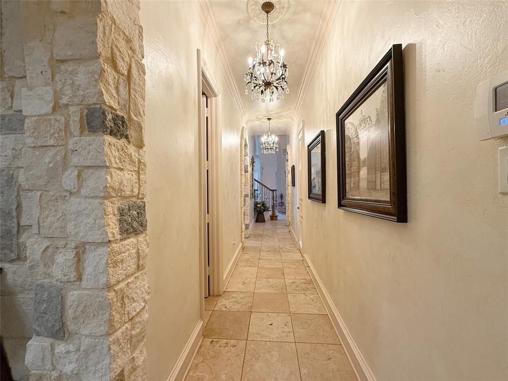 1919 Kings Pass Heath, TX 75032 - Photo 26 of 38 Corridor with crown molding, a chandelier, and a textured wall