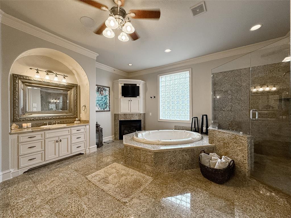 1919 Kings Pass Heath, TX 75032 - Photo 28 of 38 Full bathroom with granite tiled floors, a stall shower, vanity, a garden tub, and ceiling fan
