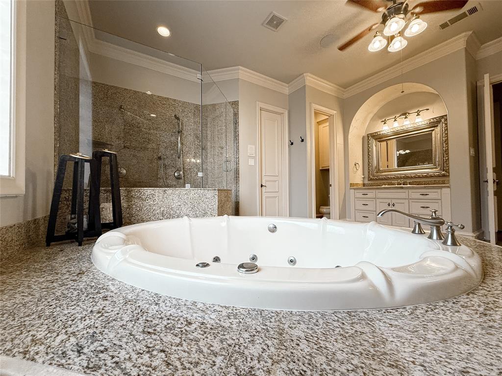 1919 Kings Pass Heath, TX 75032 - Photo 29 of 38 Bathroom featuring a shower stall, crown molding, vanity, a jetted tub, and ceiling fan