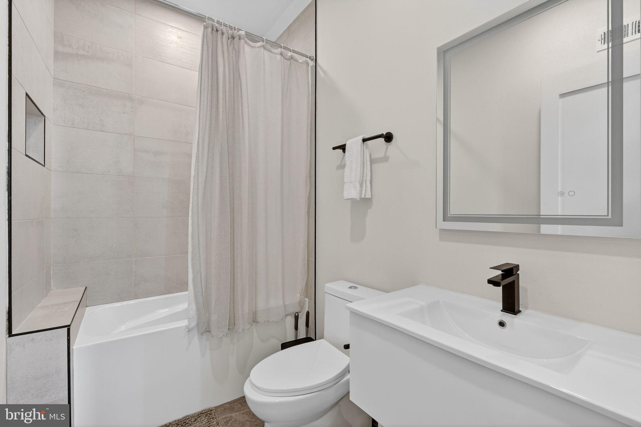 1307 Longfellow Street Northwest, Unit 8 Washington, DC 20011 - Photo 12 of 26 a bathroom with a sink a toilet and shower