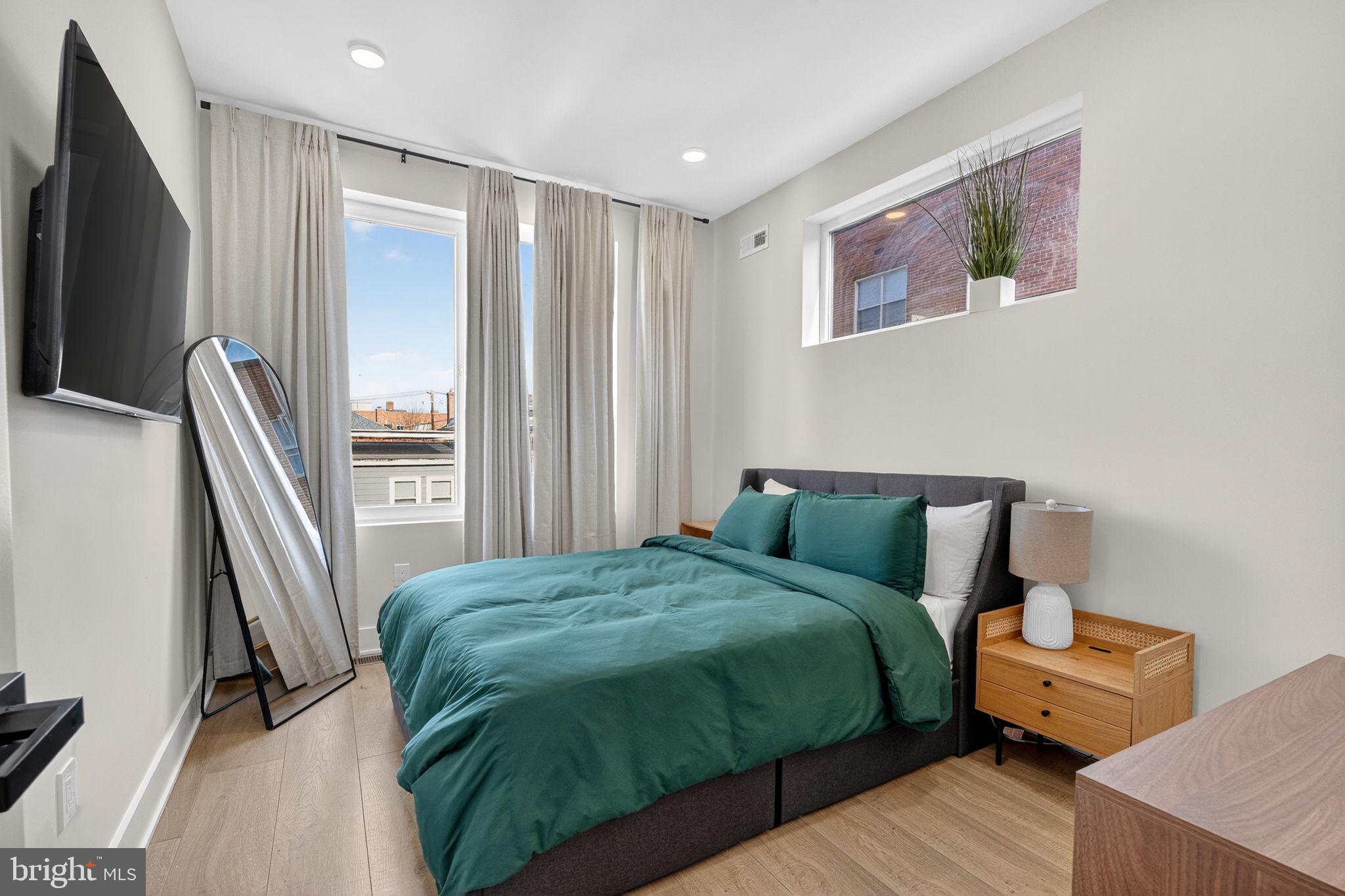 1307 Longfellow Street Northwest, Unit 8 Washington, DC 20011 - Photo 18 of 26 a bedroom with a bed and a flat screen tv