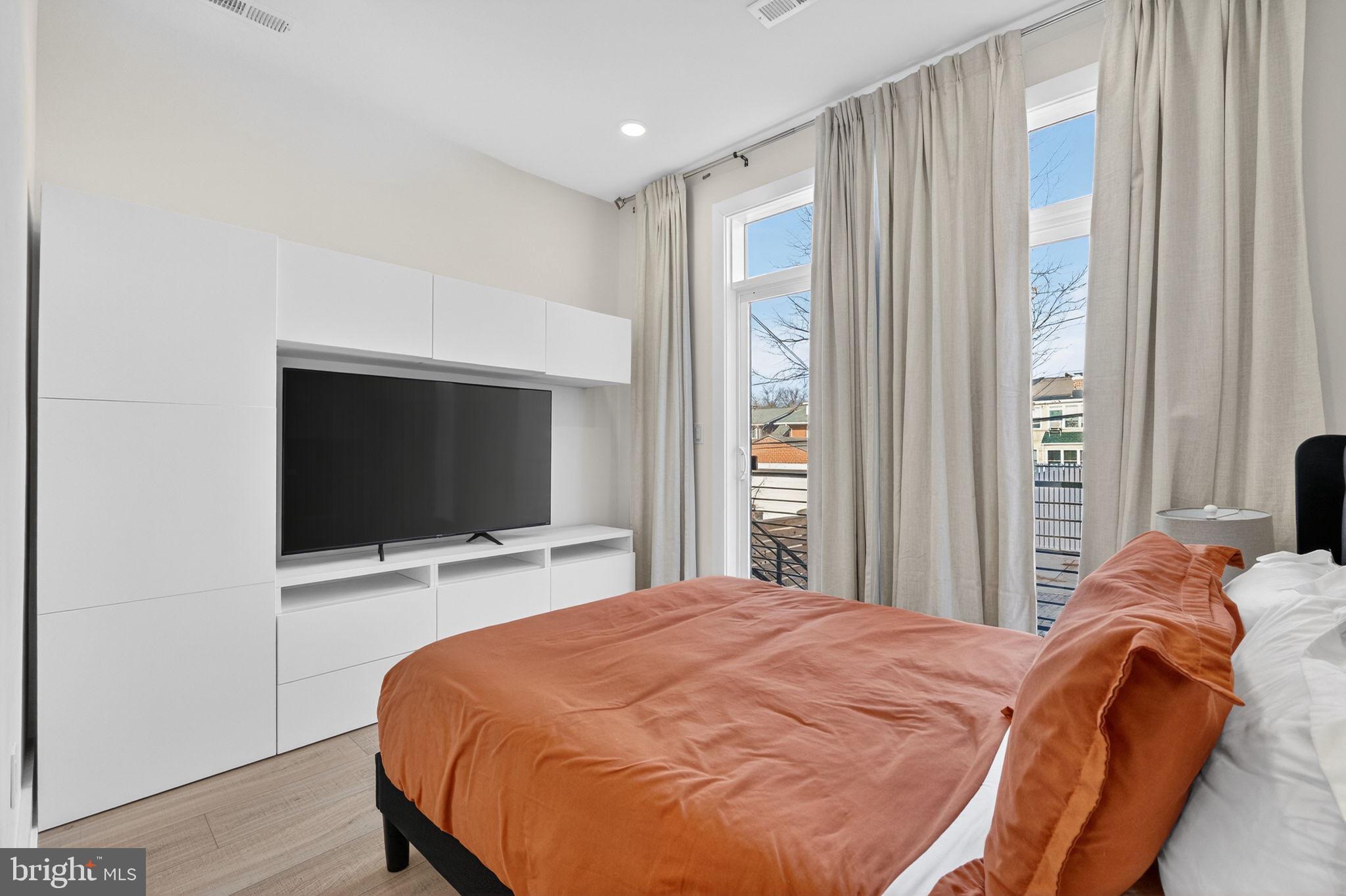 1307 Longfellow Street Northwest, Unit 8 Washington, DC 20011 - Photo 21 of 26 a bedroom with a bed tv and a window