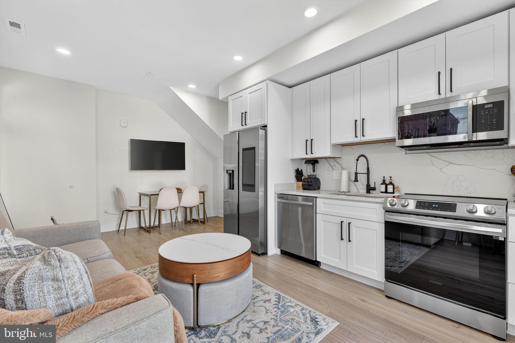 1307 Longfellow Street Northwest, Unit 8 Washington, DC 20011 - Photo 7 of 26 a kitchen with stainless steel appliances granite countertop a stove a sink and a microwave