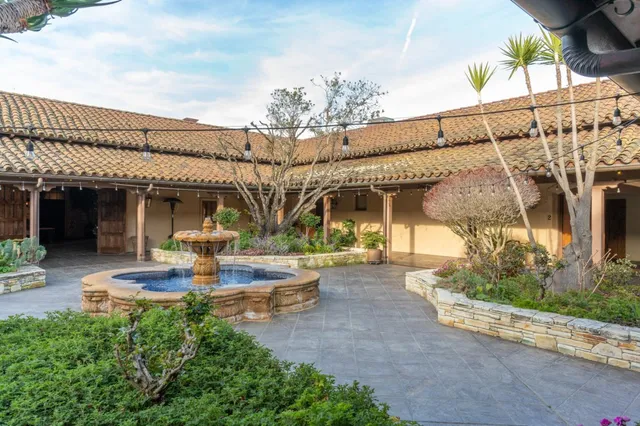 an aerial view of a house with garden space and ocean view