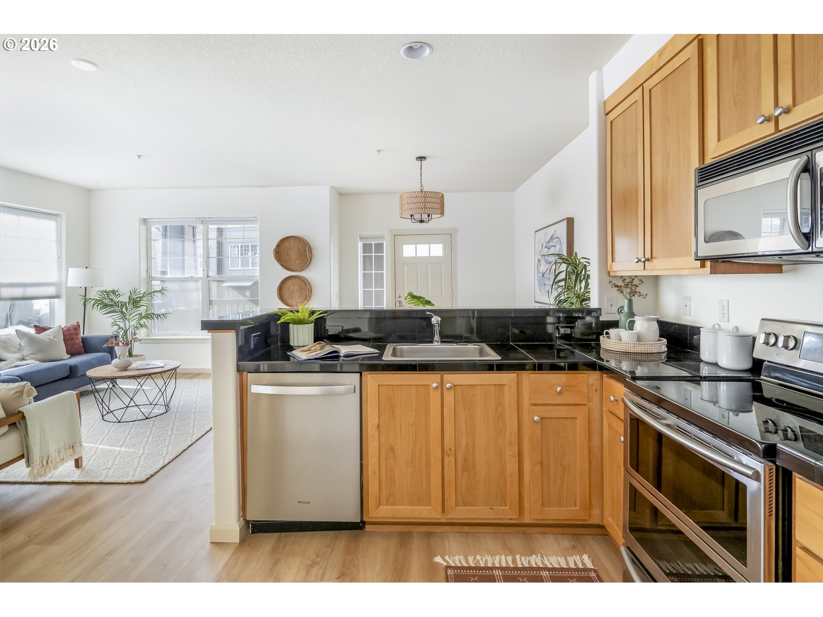 1100 Southwest 170th Avenue, Unit 100 Beaverton, OR 97003 - Photo 7 of 17 a kitchen with stainless steel appliances granite countertop a stove a sink dishwasher and white cabinets with wooden floor