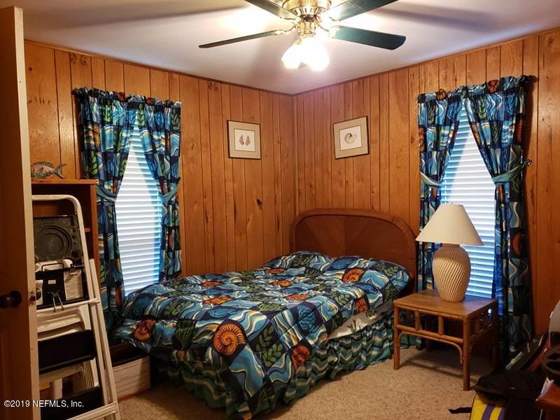 419 Marina Road Satsuma, FL 32189 - Photo 17 of 18 a bedroom with a bed and a chandelier