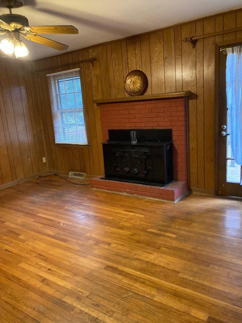 7530 Riding Trail Road Charlotte, NC 28212 - Photo 5 of 20 a view of an empty room with wooden floor and a fireplace
