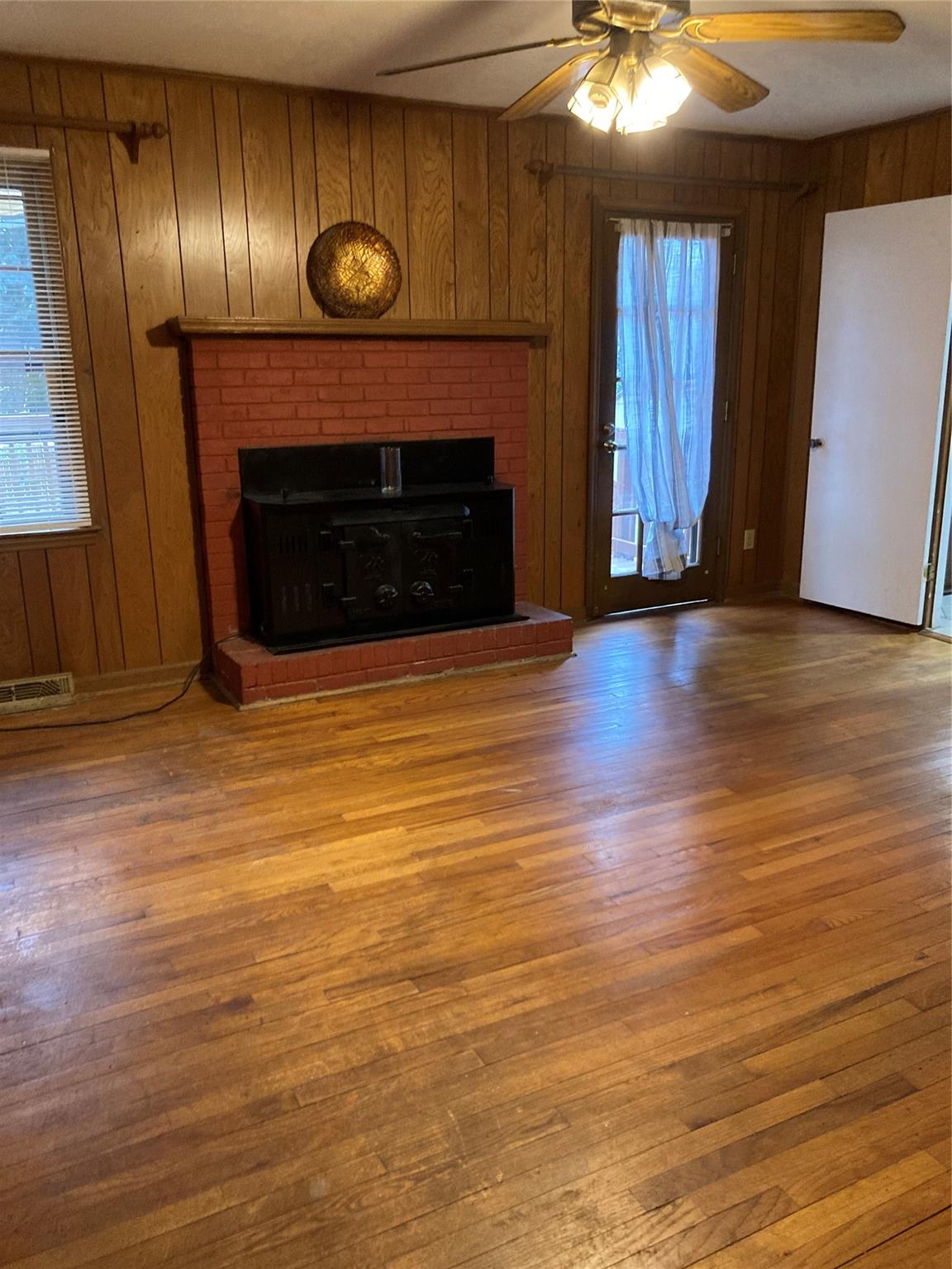 7530 Riding Trail Road Charlotte, NC 28212 - Photo 6 of 20 an empty room with wooden floor fireplace and window