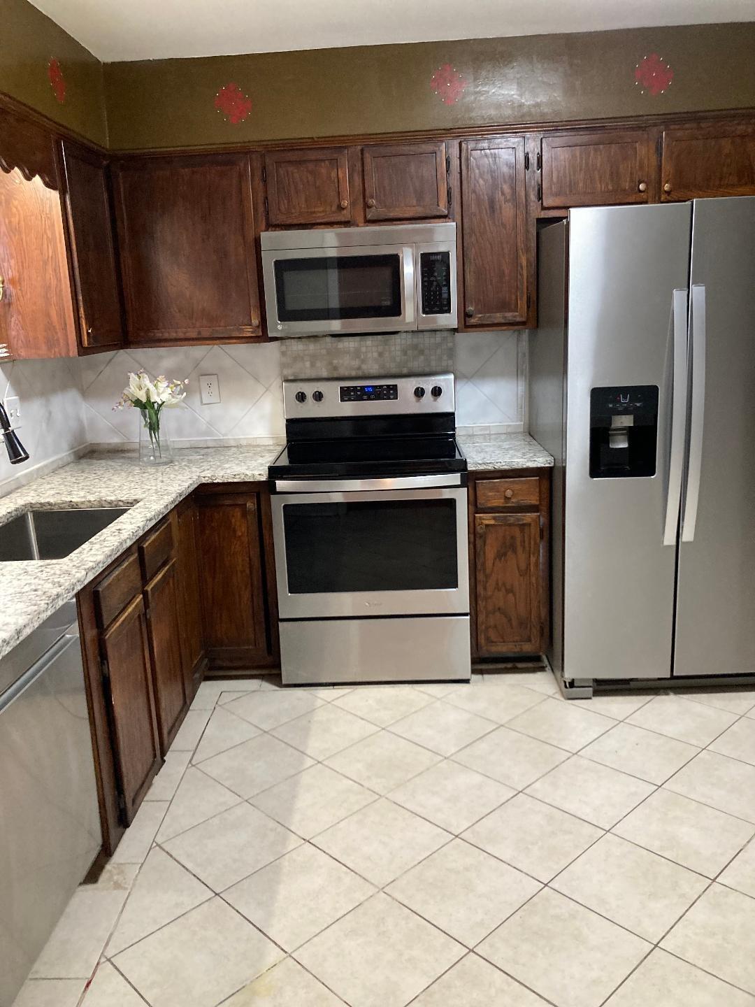 7530 Riding Trail Road Charlotte, NC 28212 - Photo 7 of 20 a kitchen with granite countertop a refrigerator stove and microwave