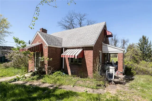 a view of a house with backyard and sitting area