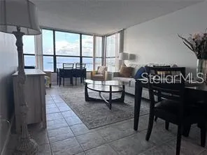 a living room with furniture a table and a large window