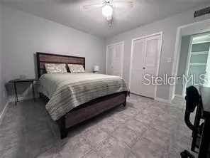 a spacious bedroom with a bed and a chandelier