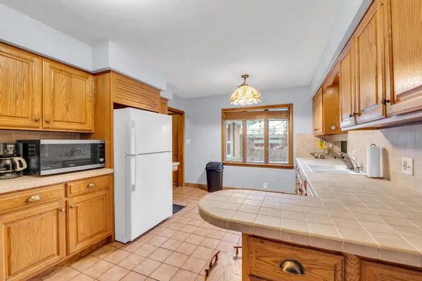 a kitchen with stainless steel appliances granite countertop a refrigerator a stove and white cabinets with wooden floor