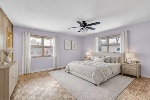 a bedroom with a large bed a chandelier and windows