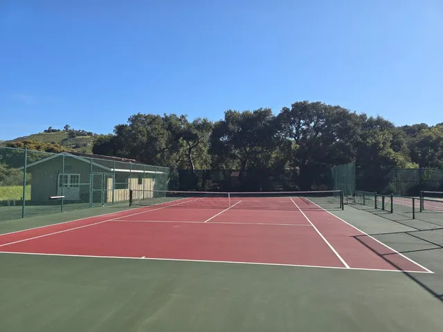 a tennis court with view of houses