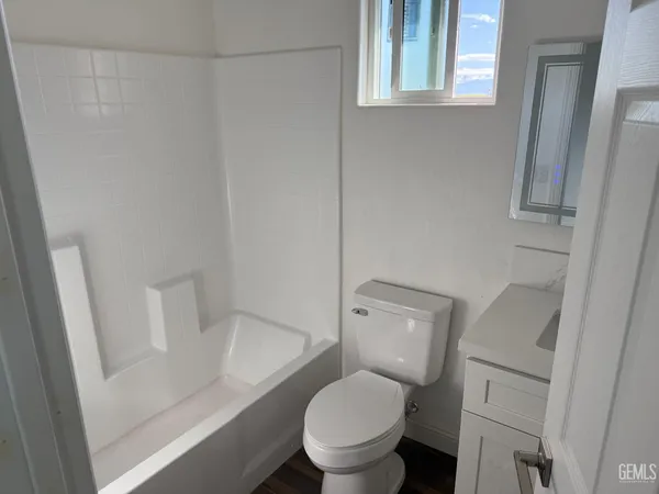 a white toilet sitting next to a bathroom sink