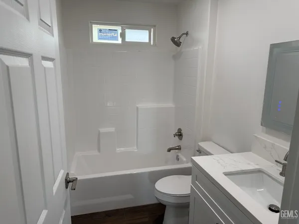 a bathroom with a sink toilet vanity and shower