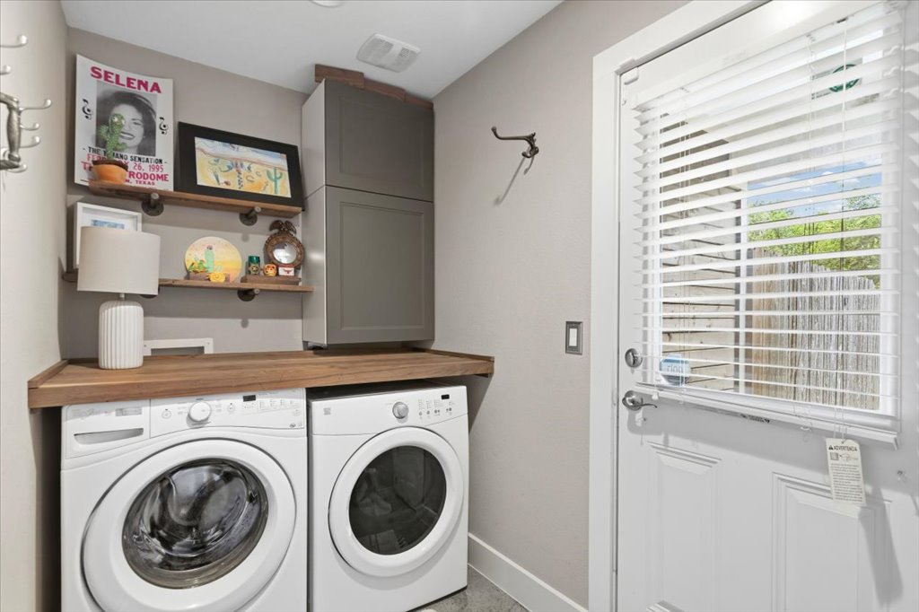 1800 Webberville Road, Unit B Austin, TX 78721 - Photo 18 of 30 Dedicated laundry area featuring a wood-finish countertop, dual open shelving, and a built-in upper cabinet