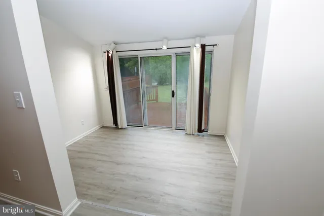 an empty room with sliding door and wooden floor