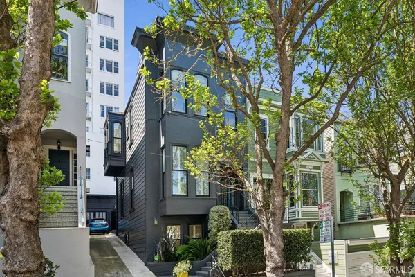 a front view of a house with a tree
