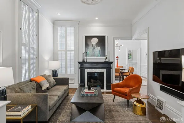 a view of a dining room and livingroom with furniture wooden floor a chandelier