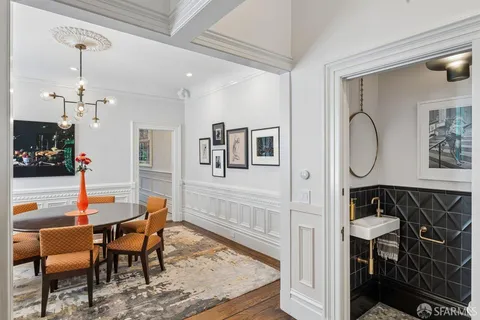 a view of a dining room and livingroom with furniture wooden floor a chandelier