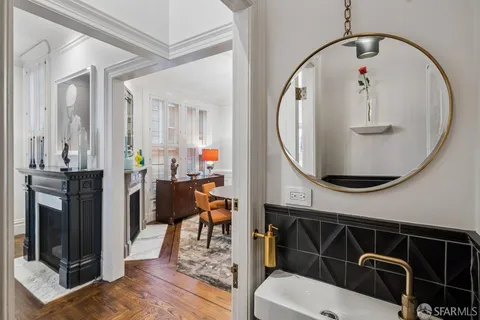 a living room with dining table a flat screen tv and a chandelier