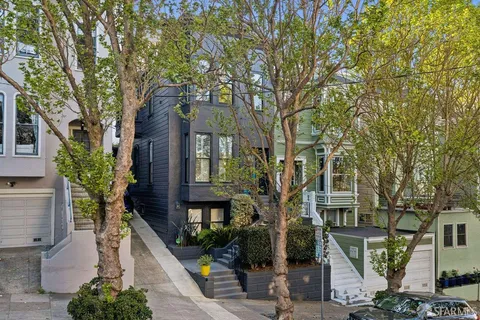a front view of a house with a tree