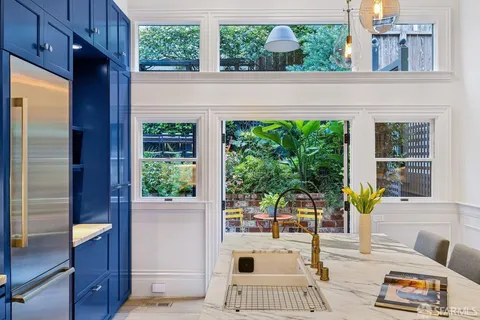 a bedroom with a bed and large windows