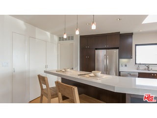 29500 Heathercliff Road, Unit 178 Malibu, CA 90265 - Photo 21 of 35 a kitchen with a dining table chairs sink and cabinets