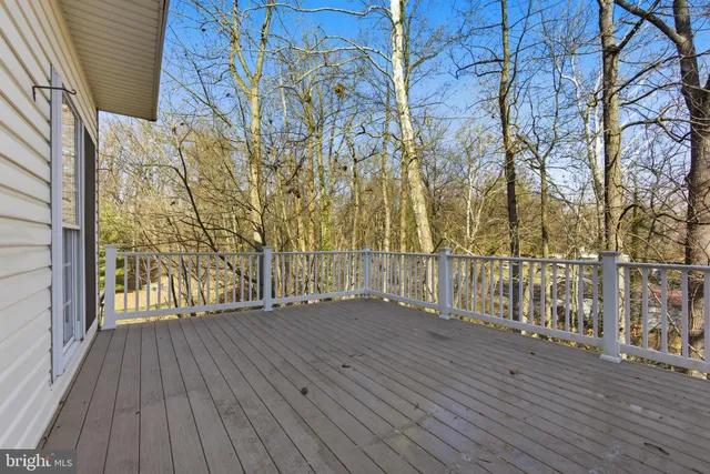 a view of wooden floor with a bench in patio