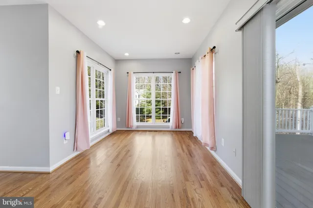 a view of hallway with windows and wooden floor