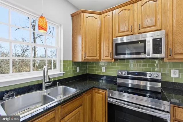 a kitchen with stainless steel appliances a sink a stove and cabinets