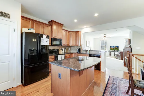 a kitchen with stainless steel appliances granite countertop a refrigerator a stove top oven a sink and a refrigerator