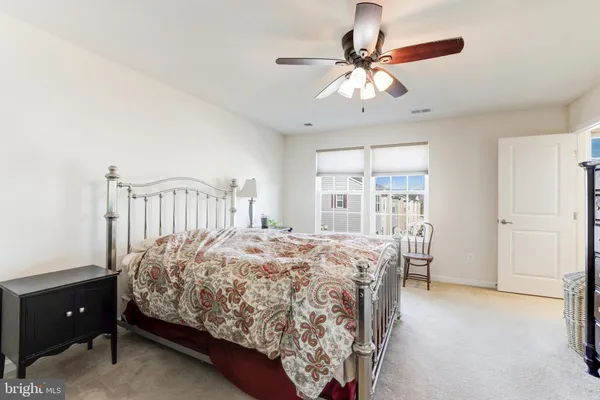 a bedroom with a bed a window and a chandelier