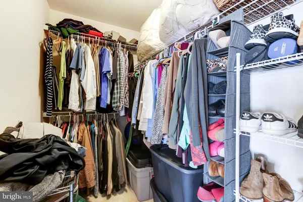 a view of walk in closet with clothes and shoes
