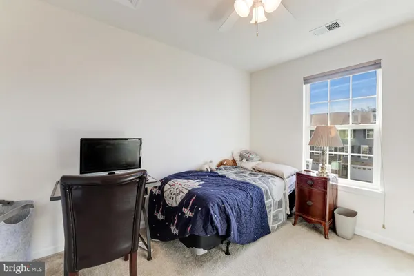 a bedroom with a bed and a flat tv screen on dresser