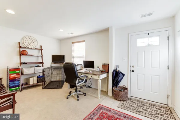 a view of a workspace with furniture and a window