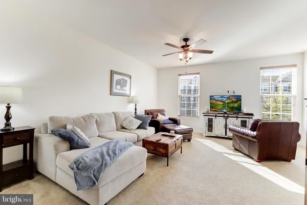 a living room with furniture ceiling fan and a window