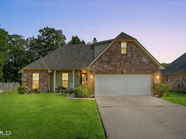 a front view of a house with a garden and plants
