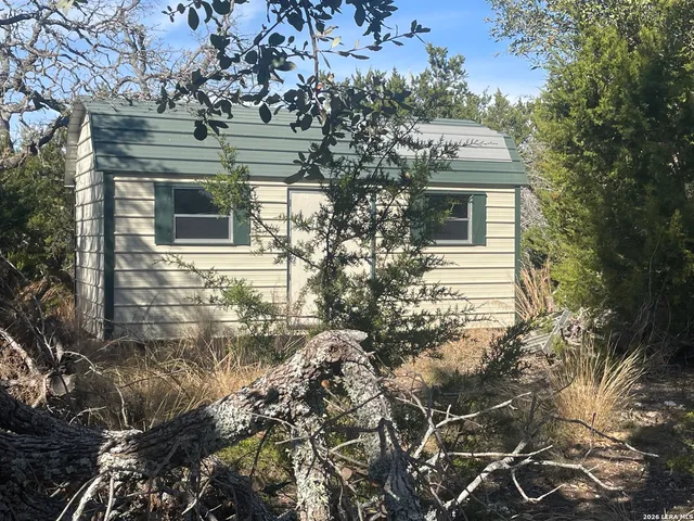 a view of a yard with wooden fence