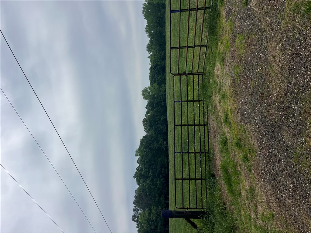 107 Humphrey Wright Road Honea Path, SC 29654 - Photo 2 of 23 This expansive lot features open fields bordered by lush greenery and a sturdy metal fence.