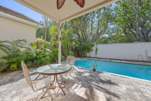 a view of a swimming pool with a patio and a yard