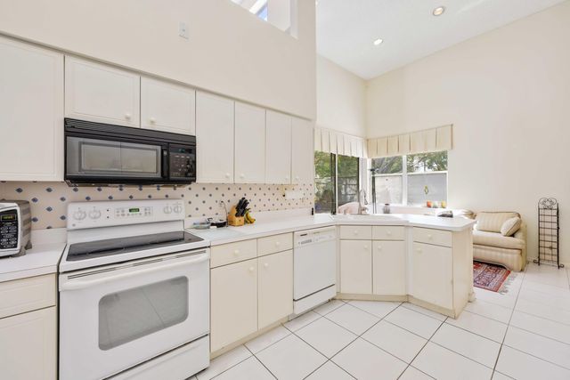 a kitchen with a refrigerator and white cabinets