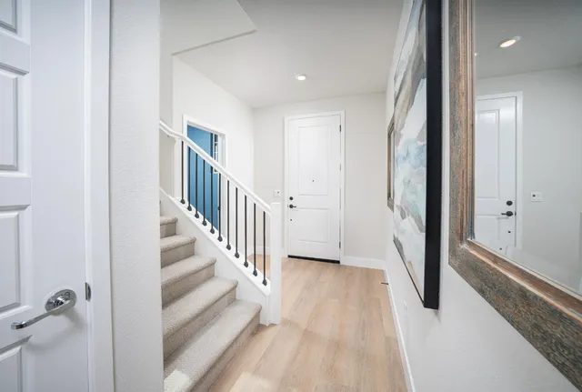 a view of a hallway with wooden floor and staircase
