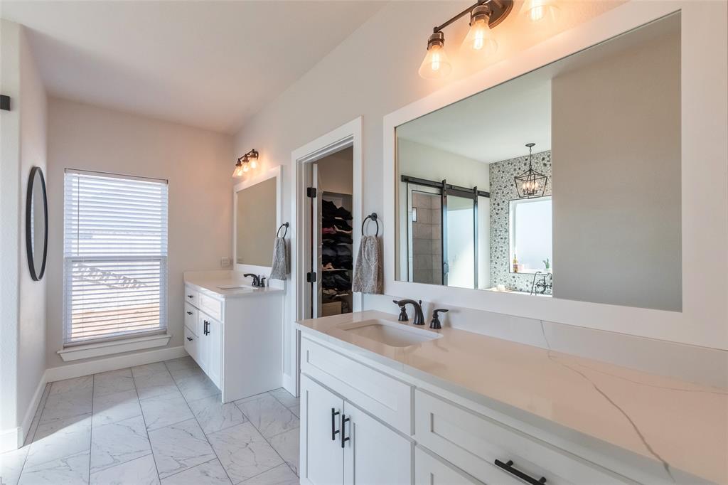 107 Kleingrass Road Abilene, TX 79606 - Photo 16 of 33 Double vanity featuring white cabinetry, quartz countertops, and matte black hardware